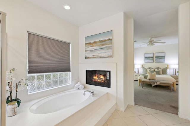 bathroom featuring ceiling fan, tile patterned flooring, and a tub