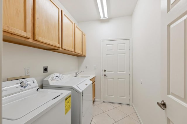 washroom with cabinets, separate washer and dryer, sink, and light tile patterned floors