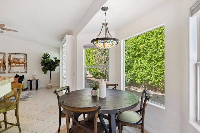 tiled dining space featuring ceiling fan and vaulted ceiling