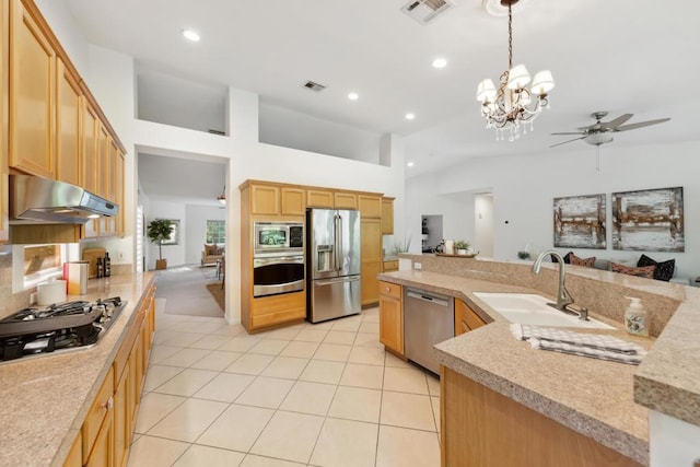 kitchen with light tile patterned flooring, light brown cabinetry, sink, decorative light fixtures, and stainless steel appliances