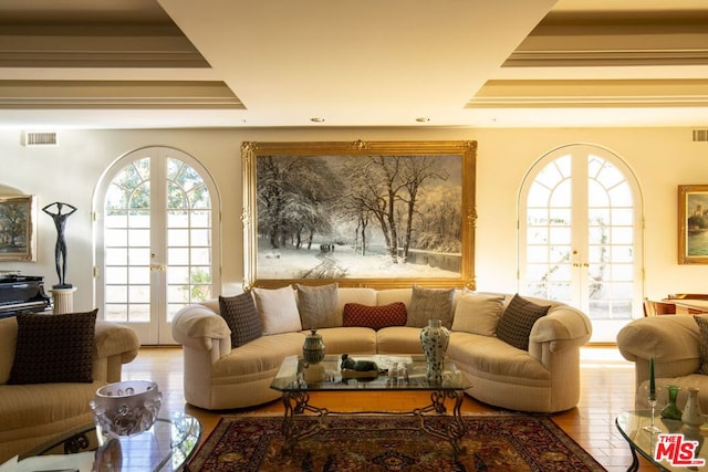 living room featuring french doors, wood-type flooring, and a raised ceiling