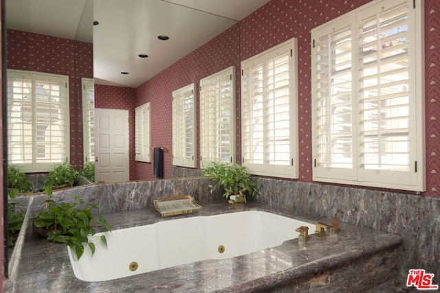 bathroom with a wealth of natural light and a tub to relax in