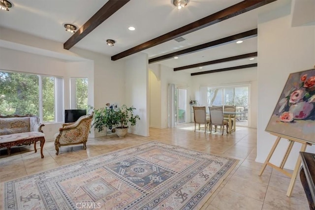 sitting room featuring light tile patterned floors and beam ceiling