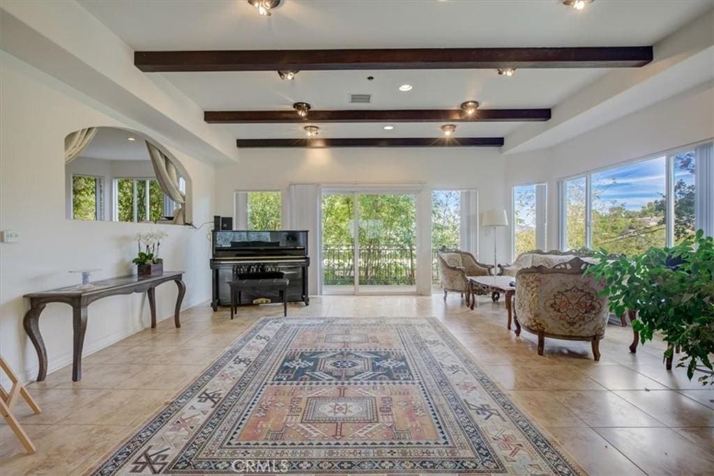 sitting room with beam ceiling, light tile patterned flooring, plenty of natural light, recessed lighting, and baseboards