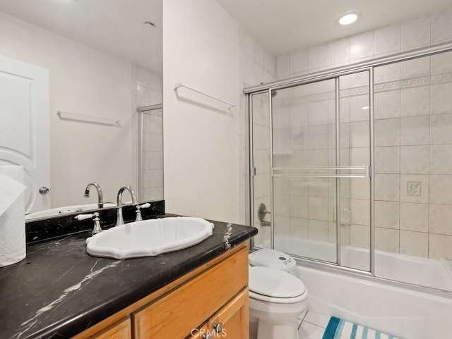 full bathroom featuring toilet, bath / shower combo with glass door, tile patterned floors, and vanity