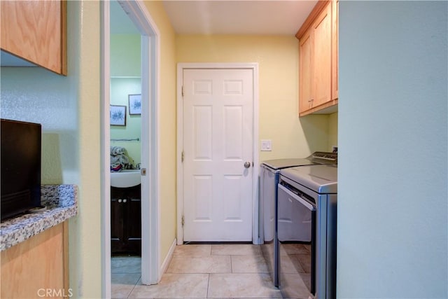 clothes washing area with cabinets, light tile patterned flooring, and separate washer and dryer