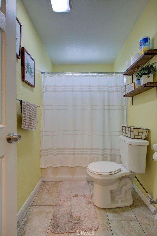 bathroom featuring toilet, tile patterned flooring, and shower / bath combo