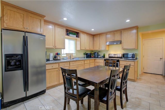 kitchen with stainless steel appliances, sink, light stone counters, and light brown cabinetry