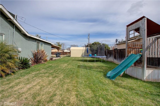 view of yard featuring a playground, a trampoline, and a storage shed