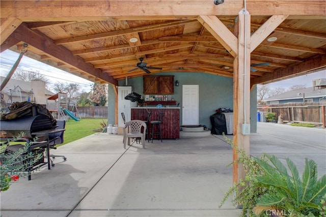 view of patio featuring a playground and exterior bar