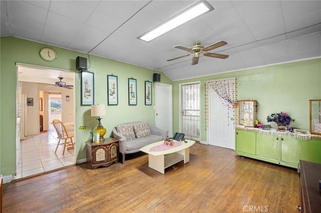 living room with lofted ceiling, wood-type flooring, and ceiling fan