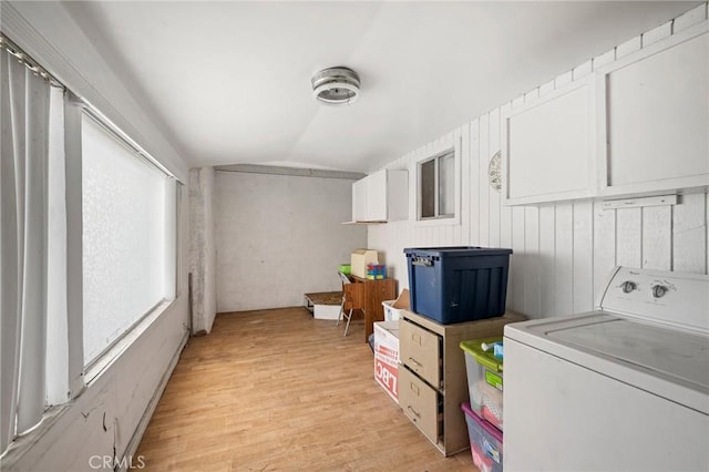 clothes washing area with washer / dryer and light hardwood / wood-style flooring