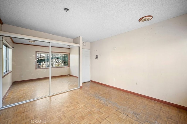 unfurnished bedroom with a closet, a textured ceiling, and light parquet floors