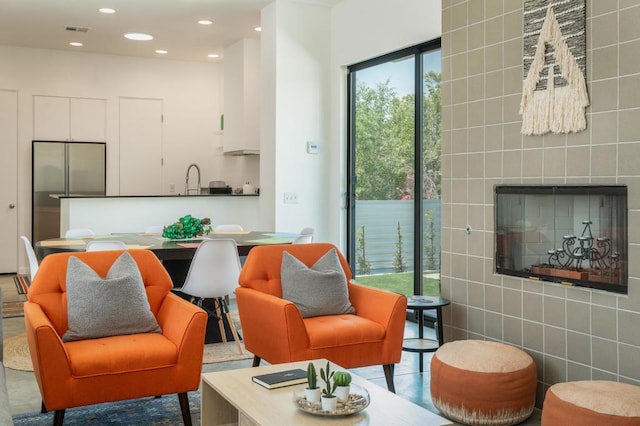 interior space with a tiled fireplace, sink, and tile walls