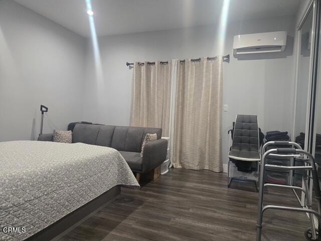 bedroom featuring dark hardwood / wood-style floors and a wall unit AC