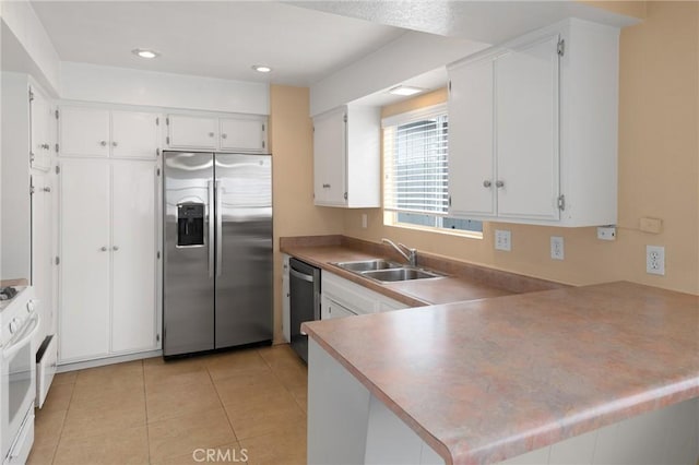 kitchen featuring light tile patterned flooring, sink, kitchen peninsula, stainless steel appliances, and white cabinets