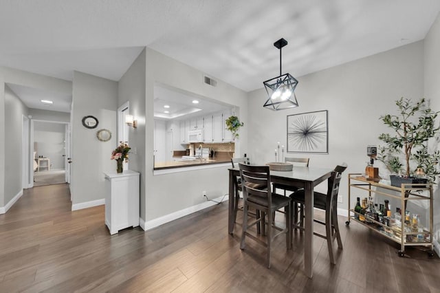 dining room featuring dark wood-type flooring and a chandelier