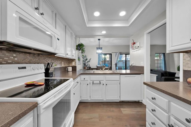 kitchen featuring white cabinetry, white appliances, a raised ceiling, and sink