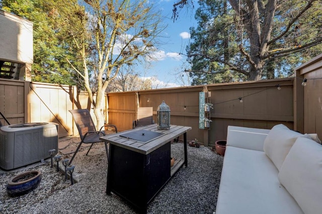 view of patio featuring central AC unit and a fire pit