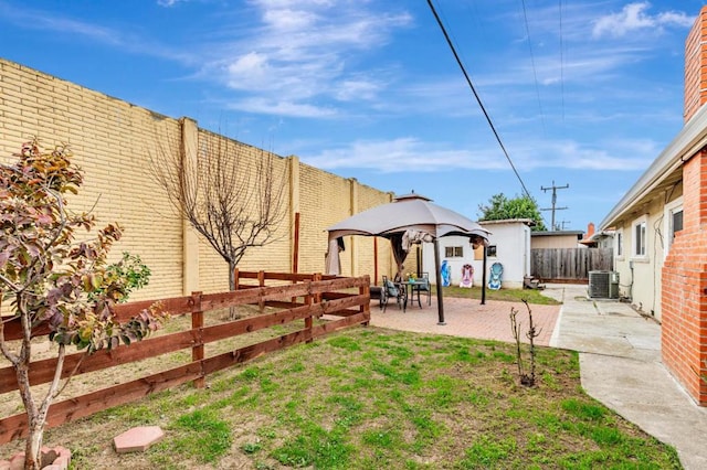 view of yard featuring central AC unit, a gazebo, and a patio area