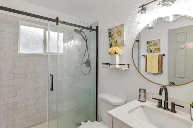 bathroom with vanity, toilet, and a shower with shower door