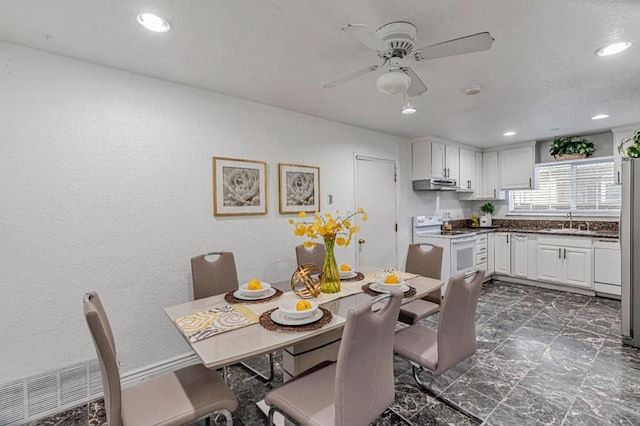 dining space with ceiling fan and sink