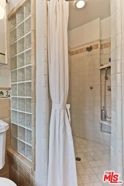 bathroom featuring toilet and a shower with shower curtain