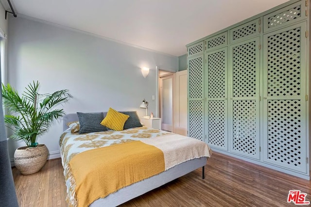 bedroom with hardwood / wood-style floors and crown molding