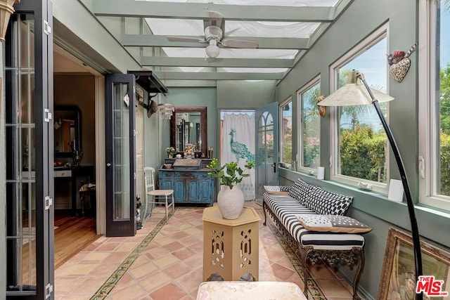 sunroom with beamed ceiling and ceiling fan