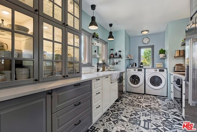 laundry area featuring independent washer and dryer and sink