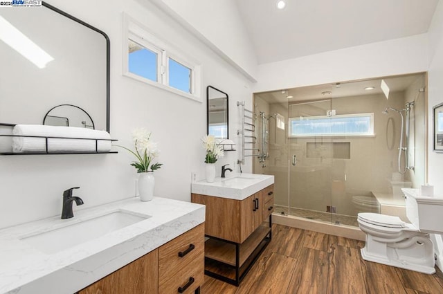 bathroom featuring walk in shower, lofted ceiling, toilet, vanity, and hardwood / wood-style floors