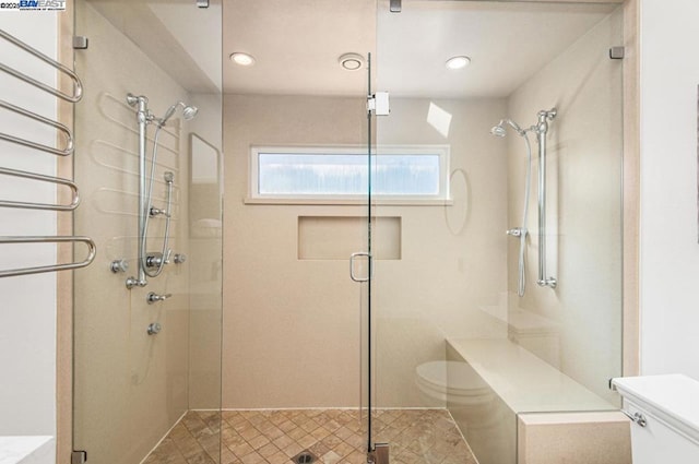 bathroom with toilet and a shower with shower door