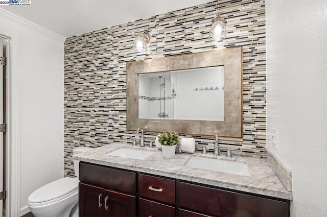 bathroom featuring vanity, decorative backsplash, ornamental molding, and toilet