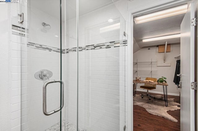 bathroom with wood-type flooring and a shower with door