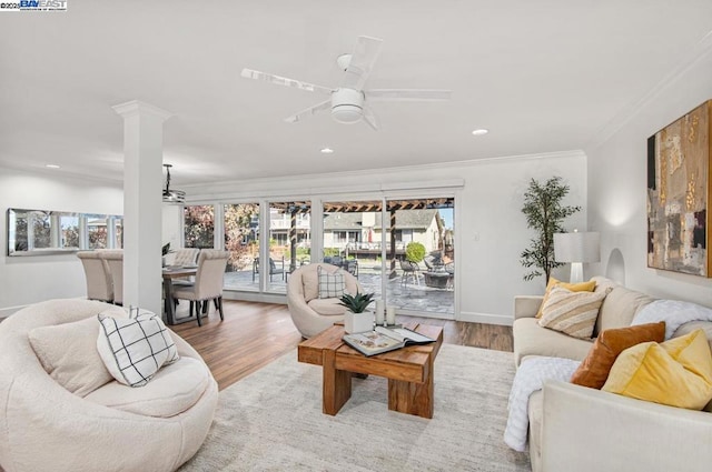 living room with decorative columns, crown molding, wood-type flooring, and ceiling fan