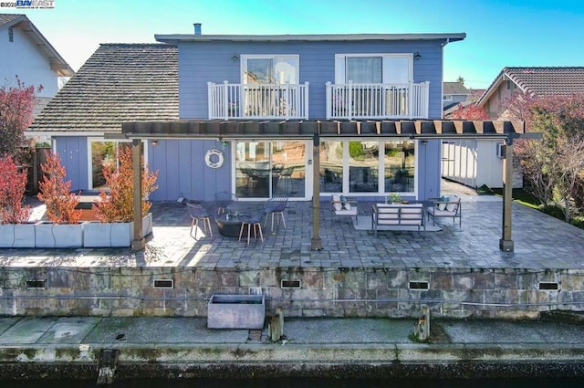 rear view of house featuring a balcony, an outdoor living space, and a patio area