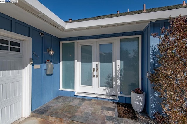 doorway to property featuring french doors and a garage