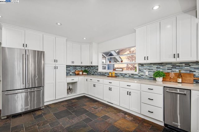 kitchen featuring appliances with stainless steel finishes, white cabinets, and backsplash