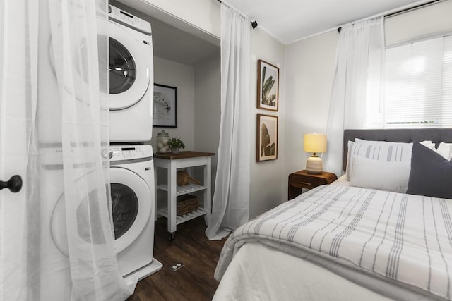 bedroom with stacked washer and dryer and dark hardwood / wood-style floors