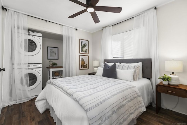 bedroom featuring dark wood-type flooring, ceiling fan, and stacked washer / dryer