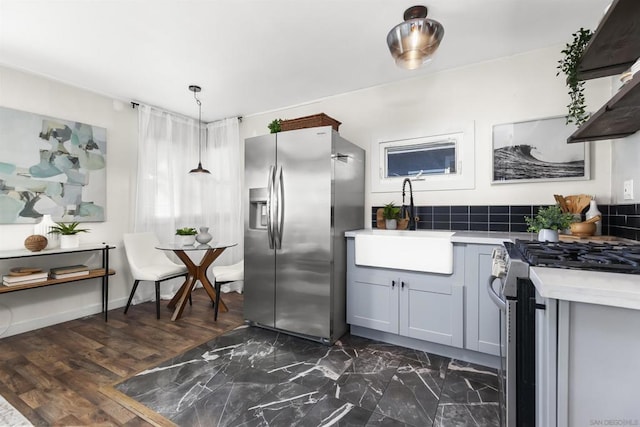 kitchen with gray cabinetry, hanging light fixtures, sink, and appliances with stainless steel finishes