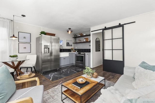 living room featuring a barn door and dark hardwood / wood-style floors