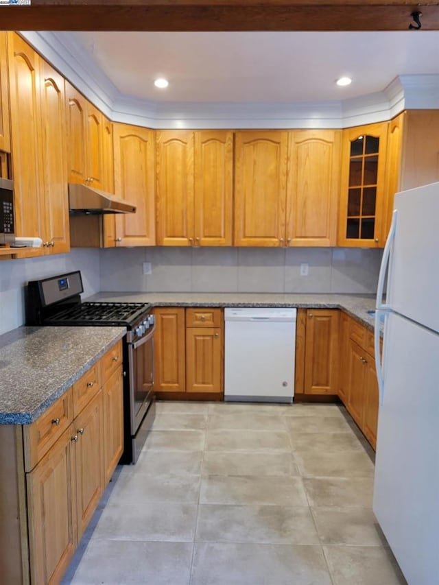 kitchen featuring dark stone countertops and white appliances