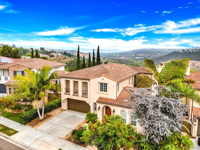 mediterranean / spanish home with a garage and a mountain view