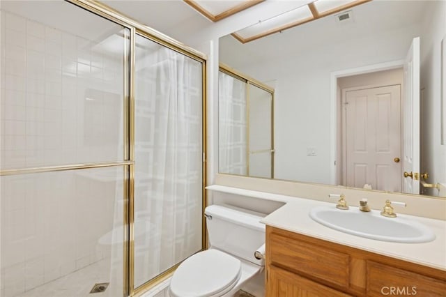 bathroom featuring a shower with door, vanity, and toilet