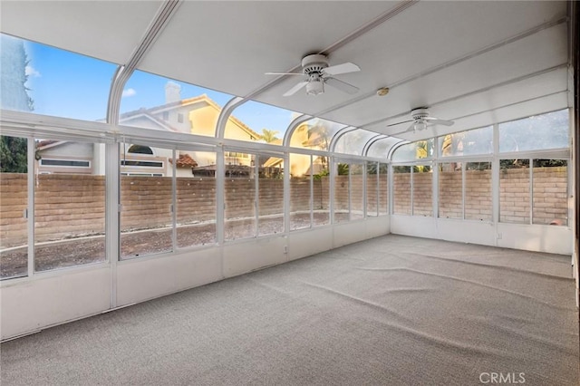 unfurnished sunroom with ceiling fan and plenty of natural light