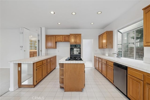 kitchen with sink, a kitchen island, black appliances, light tile patterned flooring, and tile countertops