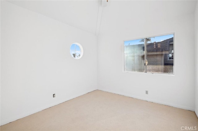 spare room featuring lofted ceiling and carpet flooring