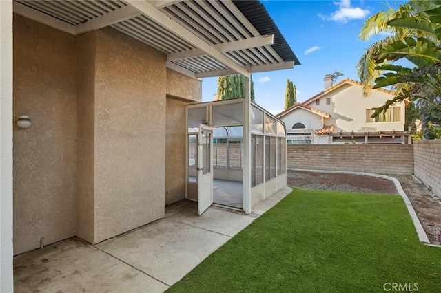 view of yard with a sunroom and a patio