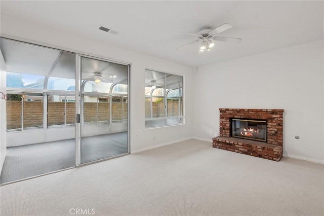 unfurnished living room featuring ceiling fan, carpet flooring, and a fireplace